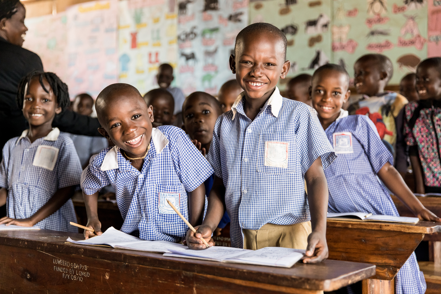 Edukans-NL-Oeganda-klas-leerlingen-lachen-onderwijs-schoolbanken-basisonderwijs