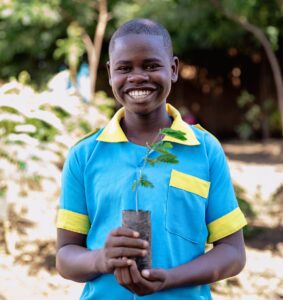 Edukans-2025-March-Malawi-Basic-Education-Eco-star-schools planting tree boy Tonny Banda school orchard 2 - small