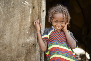Meisje met kleurrijke kleding voor deur Ethiopië onderwijs Edukans